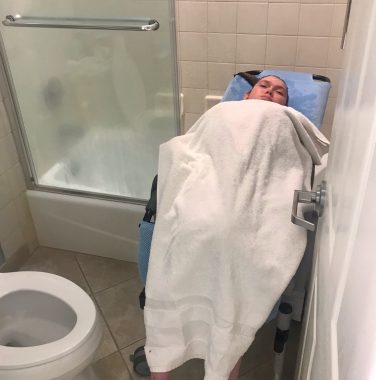 creative solutions | SMA News Today | Halsey sits on her bathroom/shower chair, which is reclining through the opening of the shower.