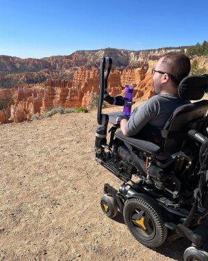 Cure SMA | SMA News Today | A daytime shot from behind Kevin as he sits in his power wheelchair overlooking the majestic Bryce Canyon in Utah