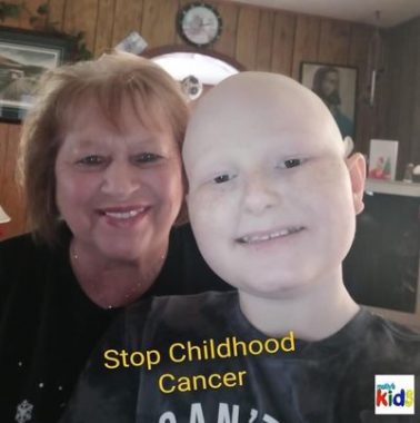 community support | SMA News Today | Aaron Collier poses with his grandmother, Cathy Campbell, in their home. Text on the photo says, "Stop Childhood Cancer"