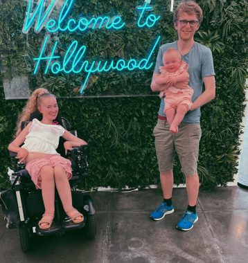 follow their dreams | SMA News Today | 31 Days of SMA | photo of Tonje, in wheelchair, with Morten and baby Gulla. All are in front of a neon "Welcome to Hollywood" sign