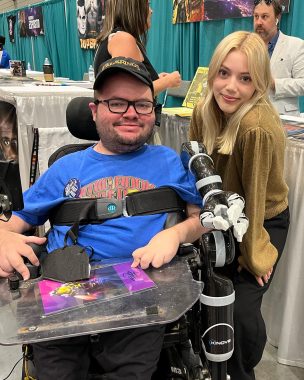 living with SMA | SMA News Today | Kevin Schaefer poses next to actor Grace Van Dien at a recent pop culture convention. 