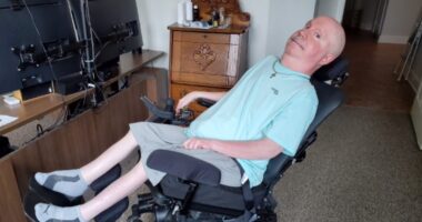 A man reclines in a wheelchair.