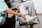 wearable device | SMA News Today | Aids | Person helping to raise leg of patient in wheelchair